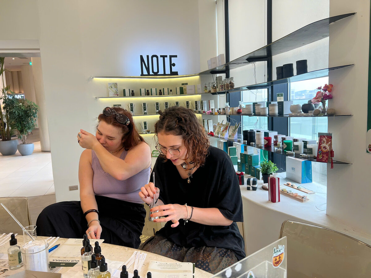 A traveler smelling fresh perfume notes at NOTE The Scent Lab Lotte Mall West Lake Hanoi - discovering Tay Ho's signature scents